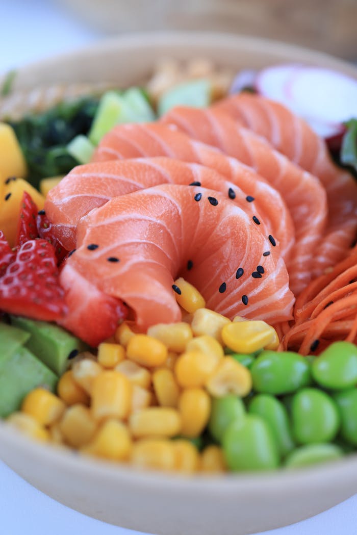 about-us-02 Delicious salmon poke bowl with fresh vegetables and fruits for a healthy meal.